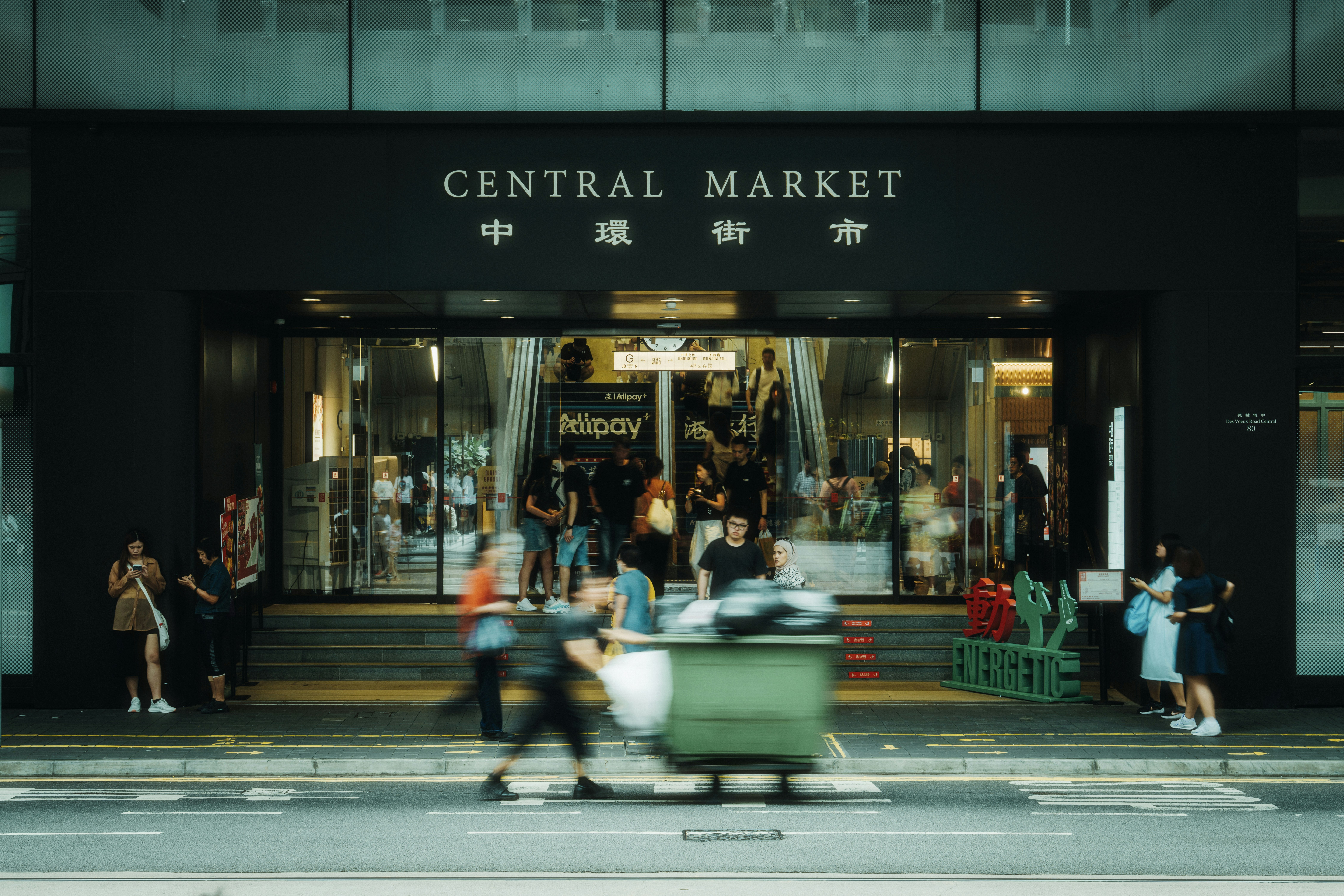 People enter and exit the central market entrance.